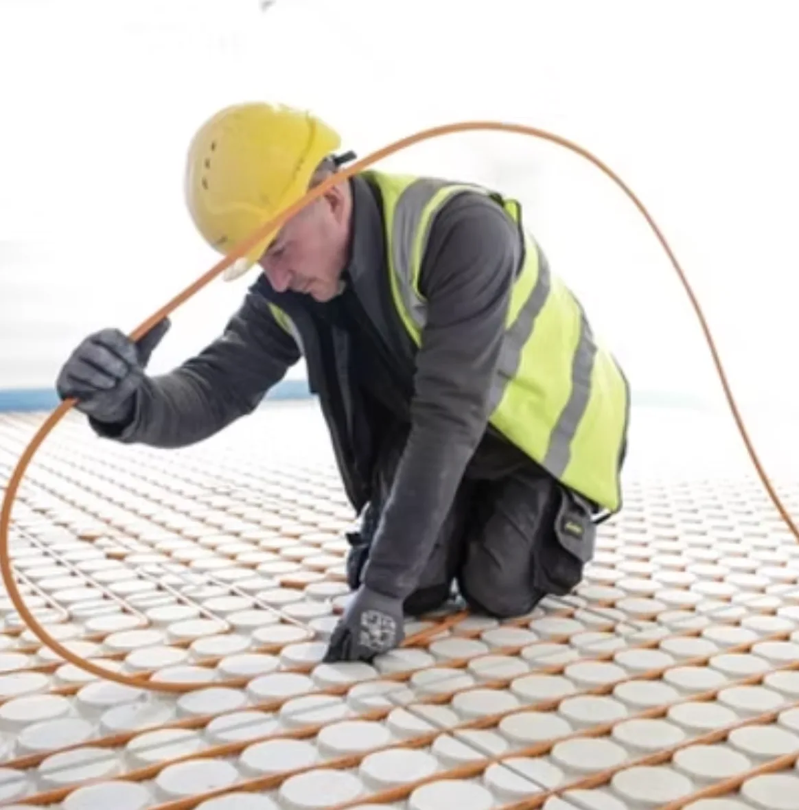 Engineer installing underfloor heating pipes